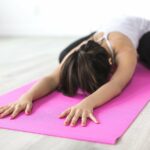 femme stretching avec tapis rose